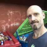 Jon standing by dumpster with rescued food on the lid